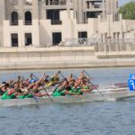 Desert Falcons dragon boat team paddling in sync during a competition.