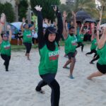 Desert Falcons dragon boat team stretching on the beach during warm-up.